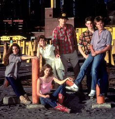 a group of people sitting on top of train tracks