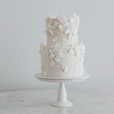 a three tiered cake with white flowers on it