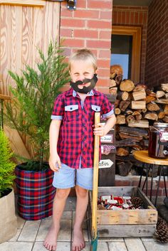 a young boy with a fake mustache holding a shovel