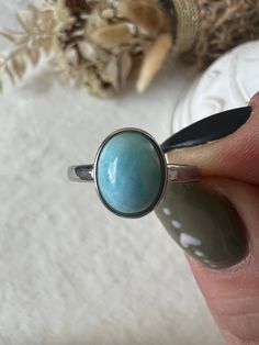 The Larimar ring in stainless steel, adjustable in size, is a piece of jewelry that carries the beauty of the Caribbean Sea. The ring's adjustable size allows it to be customized to fit different finger sizes, providing a comfortable and flexible wearing experience. The soft color of the Larimar is reminiscent of clear oceans and brings a calming and refreshing energy. Larimar is often associated with peace, calm and relaxation. Wearing this ring could therefore not only be fashionable but also serve as a symbol of serenity and inner balance. This Larimar ring, which is also size-adjustable, is not only a stylish accessory, but also an expression of natural beauty and relaxed elegance. Nickel-free Stainless Steel Round Rings, Hypoallergenic Stainless Steel Rings, Nickel Free Stainless Steel Rings For Gifts, Nickel-free Stainless Steel Rings As Gift, Adjustable Nickel-free Stainless Steel Rings, Adjustable Stainless Steel Nickel-free Rings, Adjustable Oval Turquoise Promise Ring, Adjustable Open Ring In Stainless Steel, Stainless Steel Oval Rings For Gifts