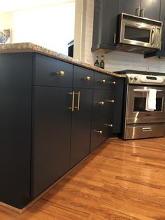 a kitchen with stainless steel appliances and wooden floors