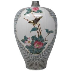 a vase with flowers and birds painted on the front, sitting against a white background