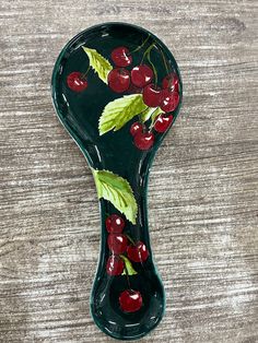 a ceramic spoon with cherries painted on it