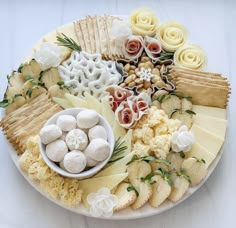 an assortment of cheeses and crackers arranged on a plate