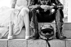 a man and woman sitting next to each other on top of a stone step wearing motorcycle gear