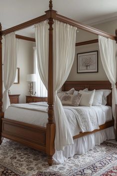 a four poster bed with white drapes and pillows