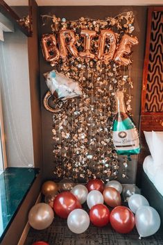 balloons and streamers are on the floor in front of a sign that says bride