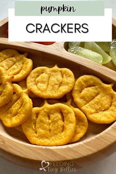 pumpkin crackers in a wooden bowl with pickles on the side