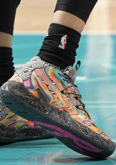 the shoes worn by basketball players during a game are decorated with multicolored patterns