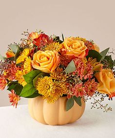 a vase filled with lots of flowers on top of a table