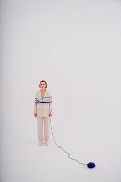 a woman standing in the snow with a ball of string attached to her neck and head