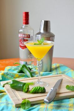 a table topped with a glass filled with liquid next to a cutting board and knife