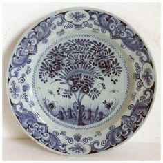 a blue and white plate with an image of a tree in the middle on it