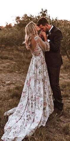 a bride and groom kissing in an open field