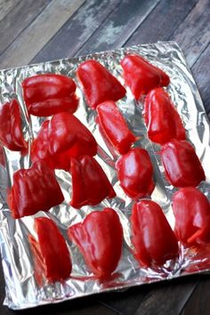 some red peppers are on a tin foil covered baking sheet and ready to be cooked