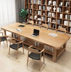 a wooden table surrounded by chairs and bookshelves