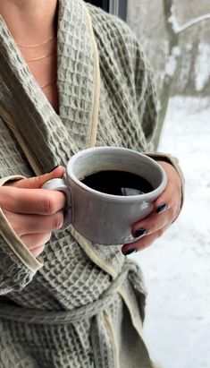 a woman holding a cup of coffee in her hands