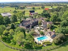 an aerial view of a large home with a pool in the yard and trees surrounding it