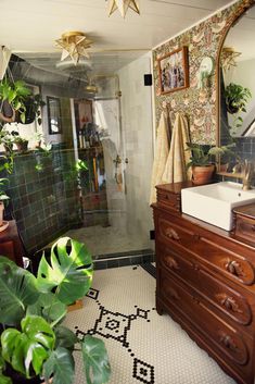 a bathroom with a sink, mirror and potted plants