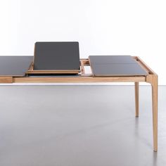 two laptops sitting on top of a table with one open and the other closed