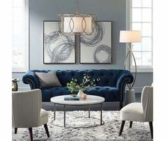 a living room with blue couches and white chairs