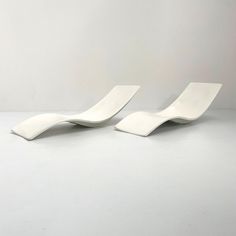 two white chairs sitting next to each other