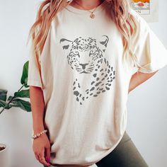 Introducing our fierce and fabulous Leopard Print Tee - the ultimate statement piece for the wild at heart! 🐆✨ Unleash your inner style predator with this trendy t-shirt adorned with a striking leopard print design. Crafted from high-quality cotton, it's as comfortable as it is stylish, making it a wardrobe essential for any fashion enthusiast. Pair it with your favorite jeans, a chic skirt, or layer it under a blazer for a versatile and on-trend ensemble. Embrace the untamed spirit of the wild with this eye-catching leopard print, a timeless pattern that never goes out of style. This is a Gildan Comfort Colors garment-dyed t-shirt.  The soft-washed, garment-dyed fabric brings extra coziness to your wardrobe while the relaxed fit makes it an excellent daily choice. The double-needle stitc Leopard Print T-shirt With Letter Print And Crew Neck, Trendy Cotton T-shirt In Leopard Print, Trendy Leopard Print Graphic T-shirt, Trendy Leopard Print T-shirt With Crew Neck, Leopard Print Graphic T-shirt For Summer, Summer Leopard Print Graphic T-shirt, Casual White Tiger Print Top, Cotton Leopard Print T-shirt For Summer, Leopard Print Graphic Tee With Crew Neck