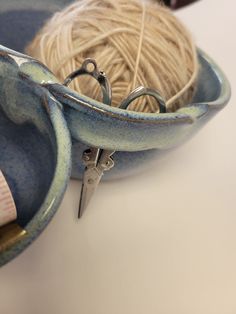 yarn and scissors in a bowl on a table