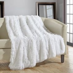 a living room with a couch, chair and white blanket