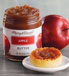 an apple butter is on a plate next to some apples