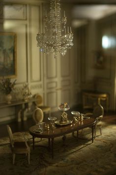 a dining room with chandelier, table and chairs