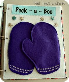 two purple mittens sitting on top of a binder