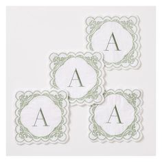 three embroidered coasters with the letter a in green and white on top of each other