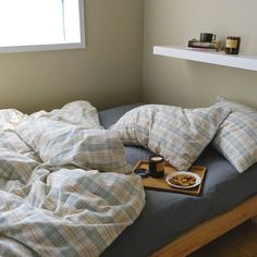 an unmade bed with food and pillows on it