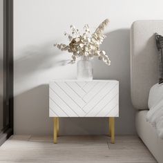 a vase with flowers sitting on top of a white cabinet