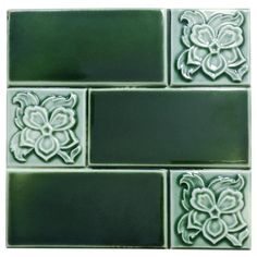 some green tiles with white flowers on the backsplashes and one is black