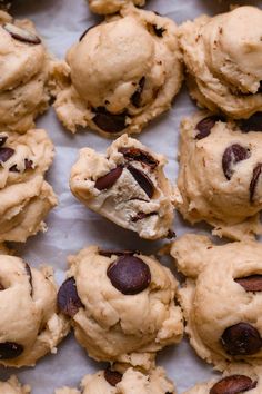 chocolate chip cookies are arranged on a sheet of parchment paper with a bite taken out