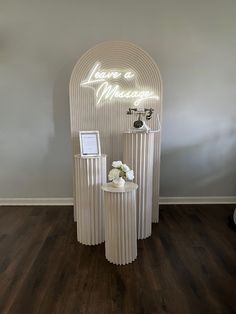 two white vases with flowers in front of a neon sign