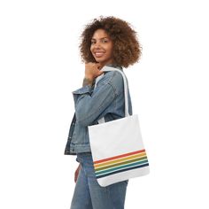 a woman holding a white tote bag with rainbow stripes