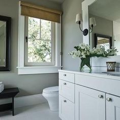 a bathroom with a sink, toilet and mirror in it's centerpieces