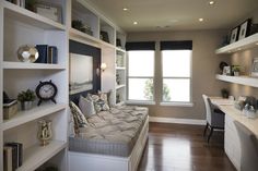 a bed sitting in the middle of a bedroom next to a desk and book shelf