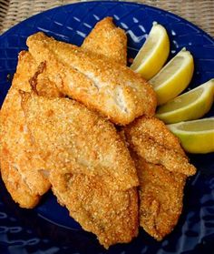 fried fish with lemon wedges on a blue plate