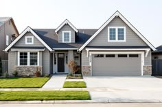 a gray house with white trim and two car garages