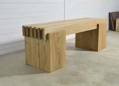 a wooden bench sitting on top of a cement floor