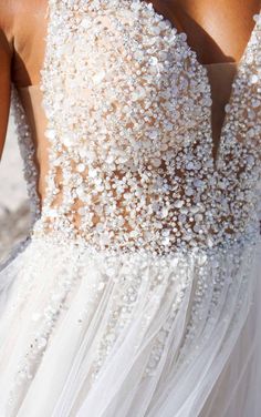 the back of a woman's wedding dress with beading on it and sheer tulle