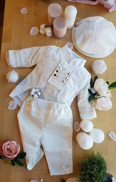 a wooden table topped with white items and flowers