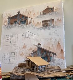 a paper model of a house sitting on top of a table next to some construction materials