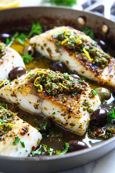 some fish with olives and herbs in a pan