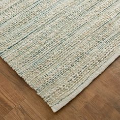 an area rug on the floor with wooden floors and wood planks in the background