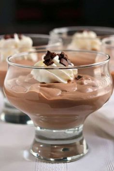 three desserts in glass dishes on a table